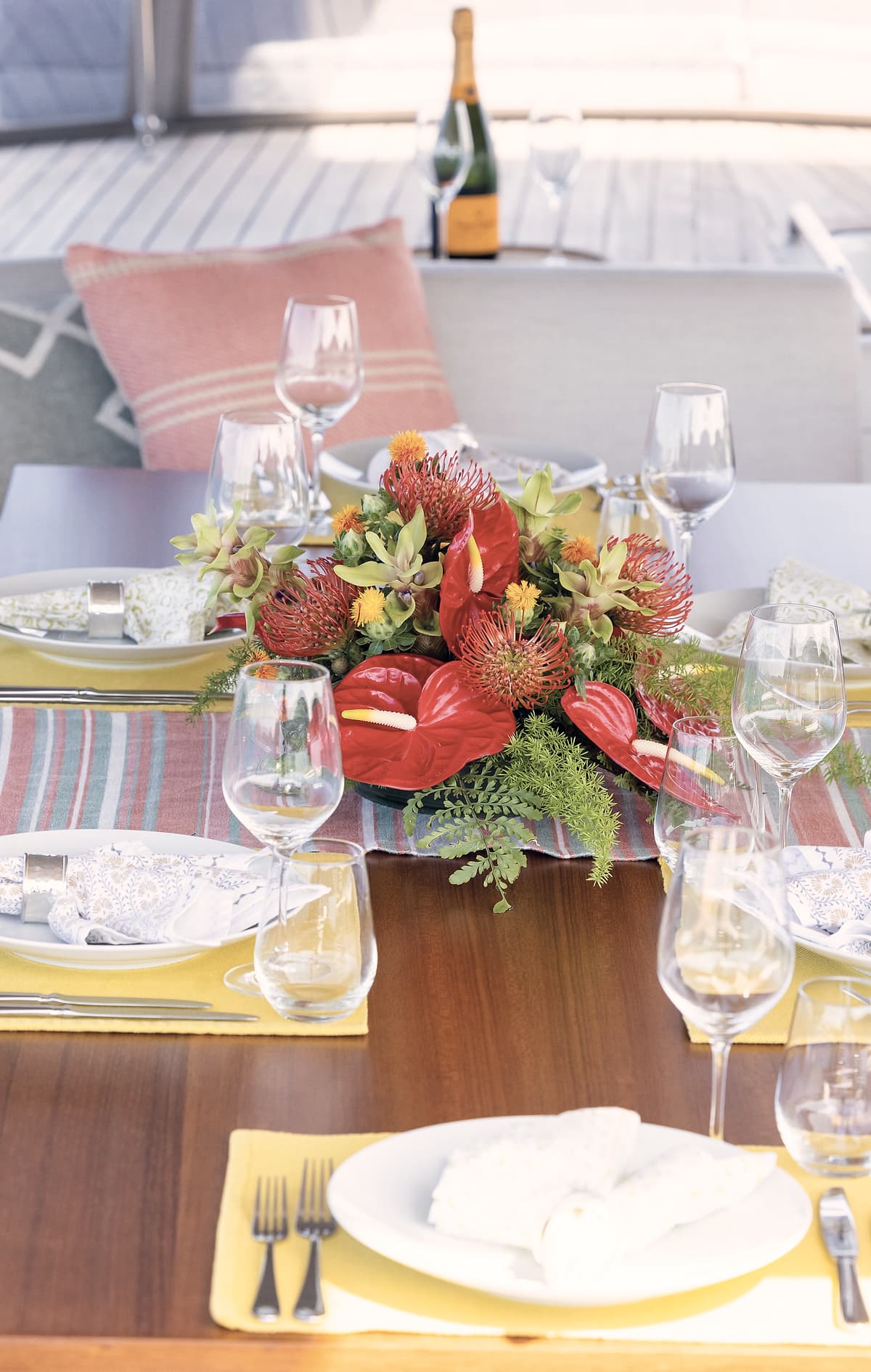 A table laid with flowers and glassware aboard a sailing yacht