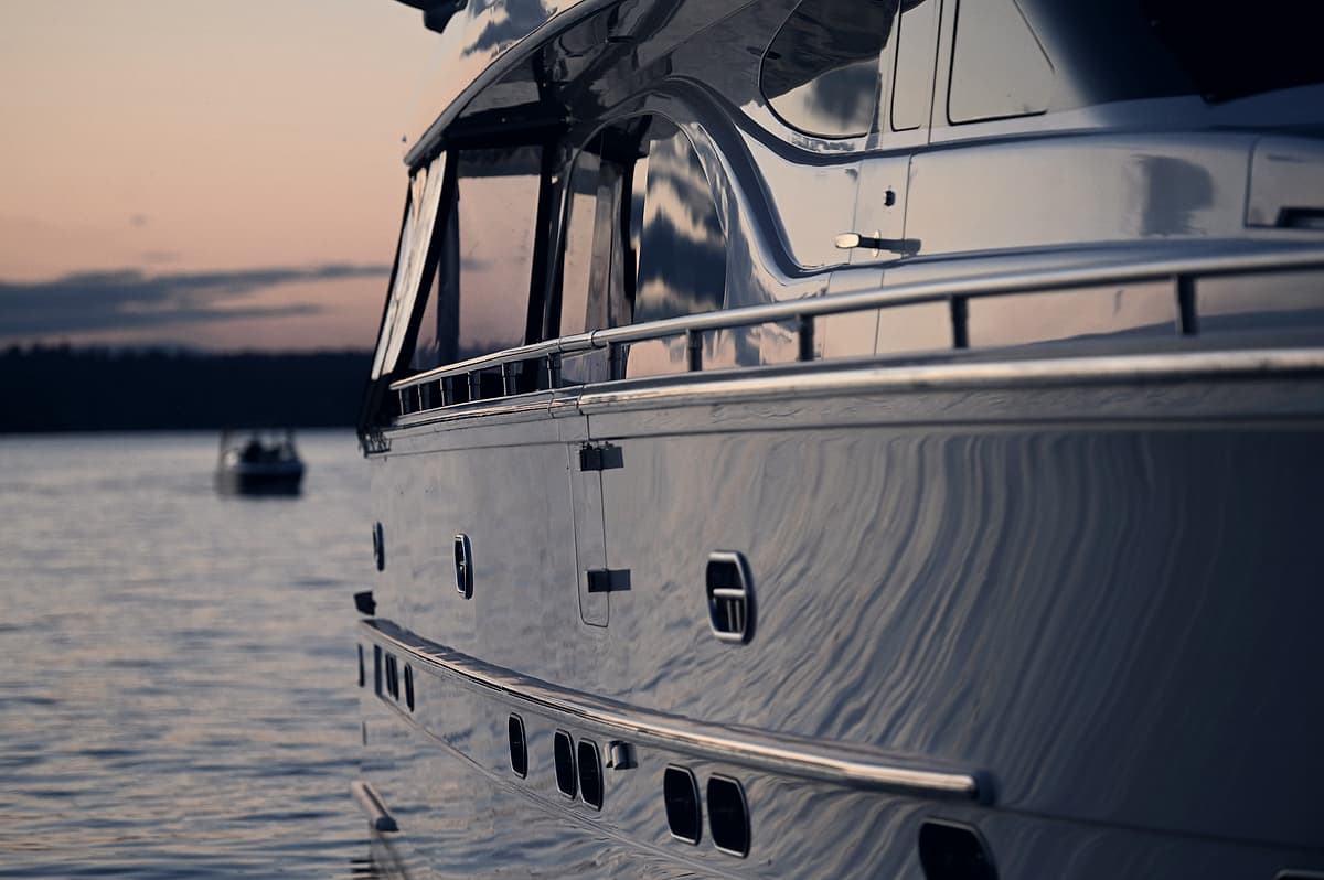 The hull and side decks of a motor yacht at dusk